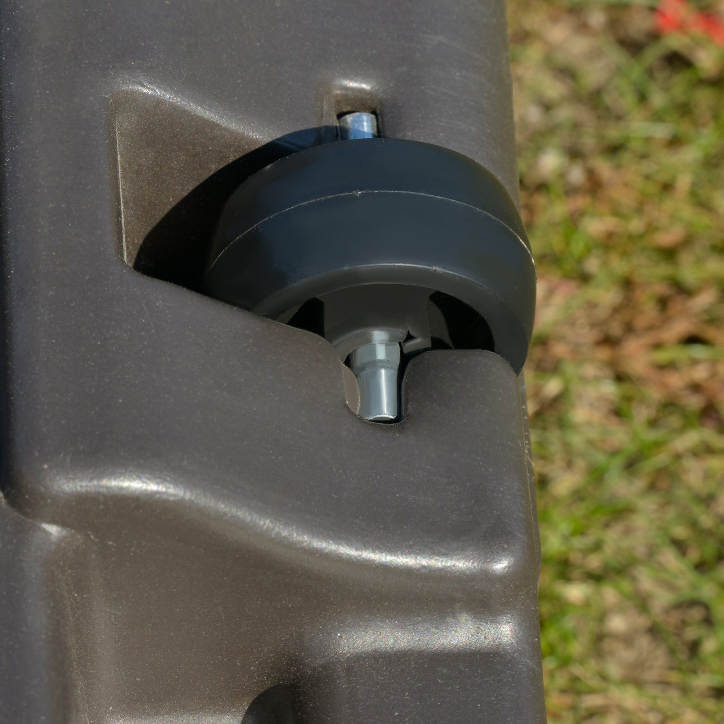 Dark gray plastic suitcase wheel and bolt assembly detail