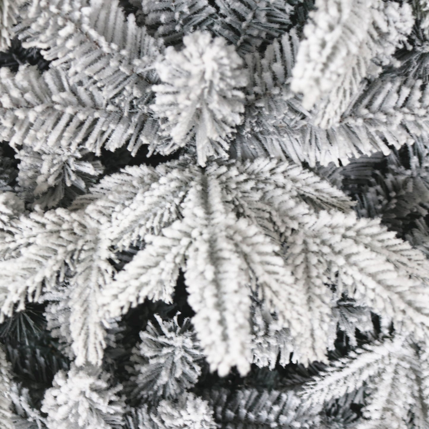 Closeup of flocked artificial pine branches with a winter wonderland effect perfect for holiday decor