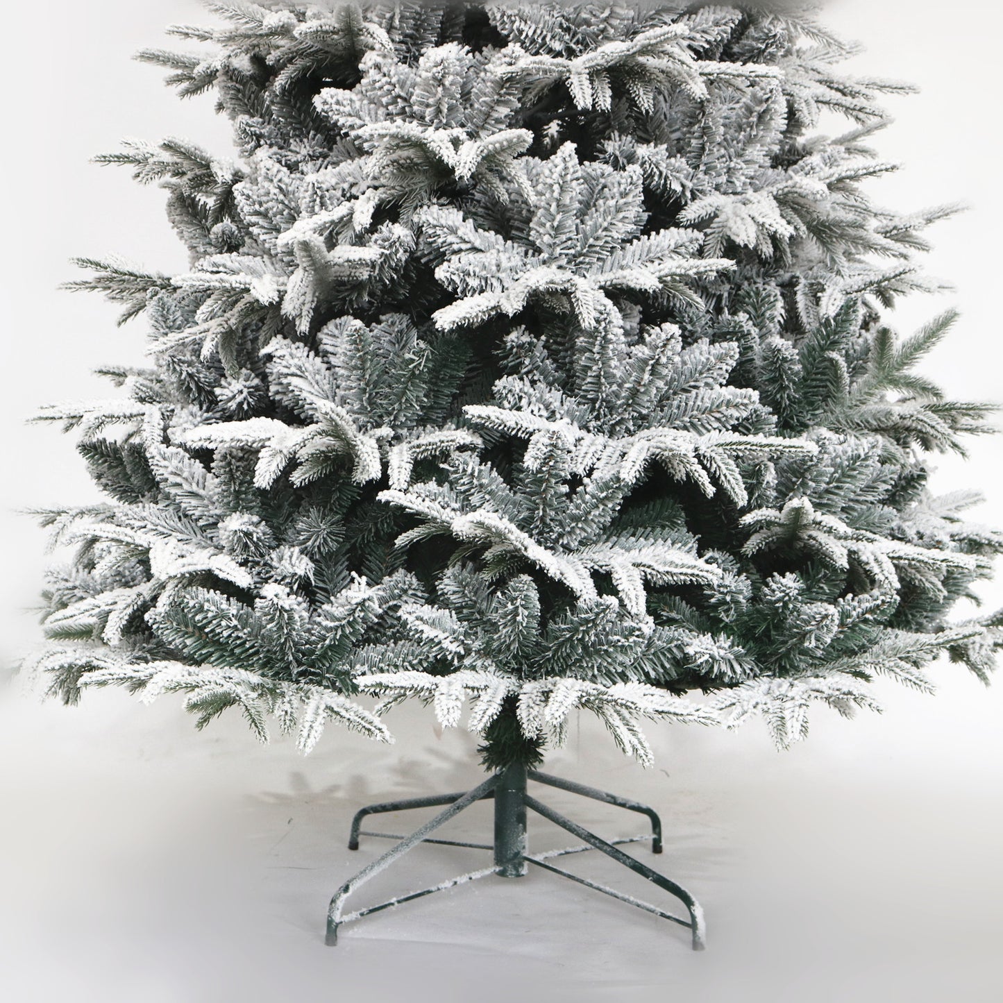 Flocked artificial Christmas tree with realistic green branches and white snow accent