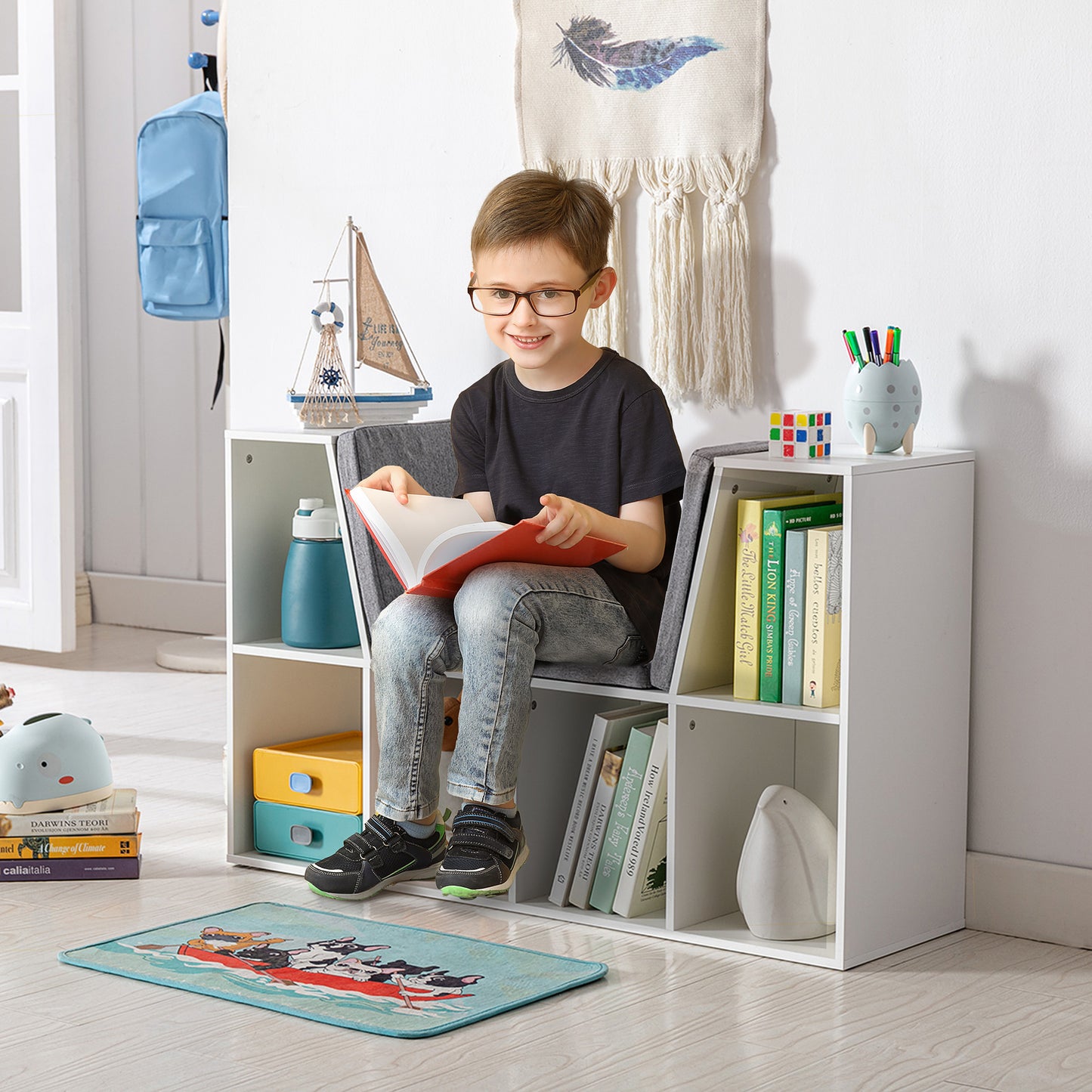 Young boy reading a book while sitting on a shelf unit