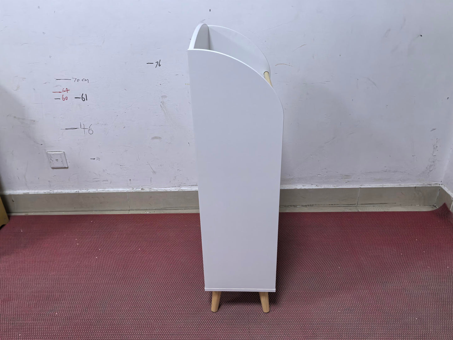 White modern storage bin with a curved opening and wooden legs perfect for organizing childrens toys