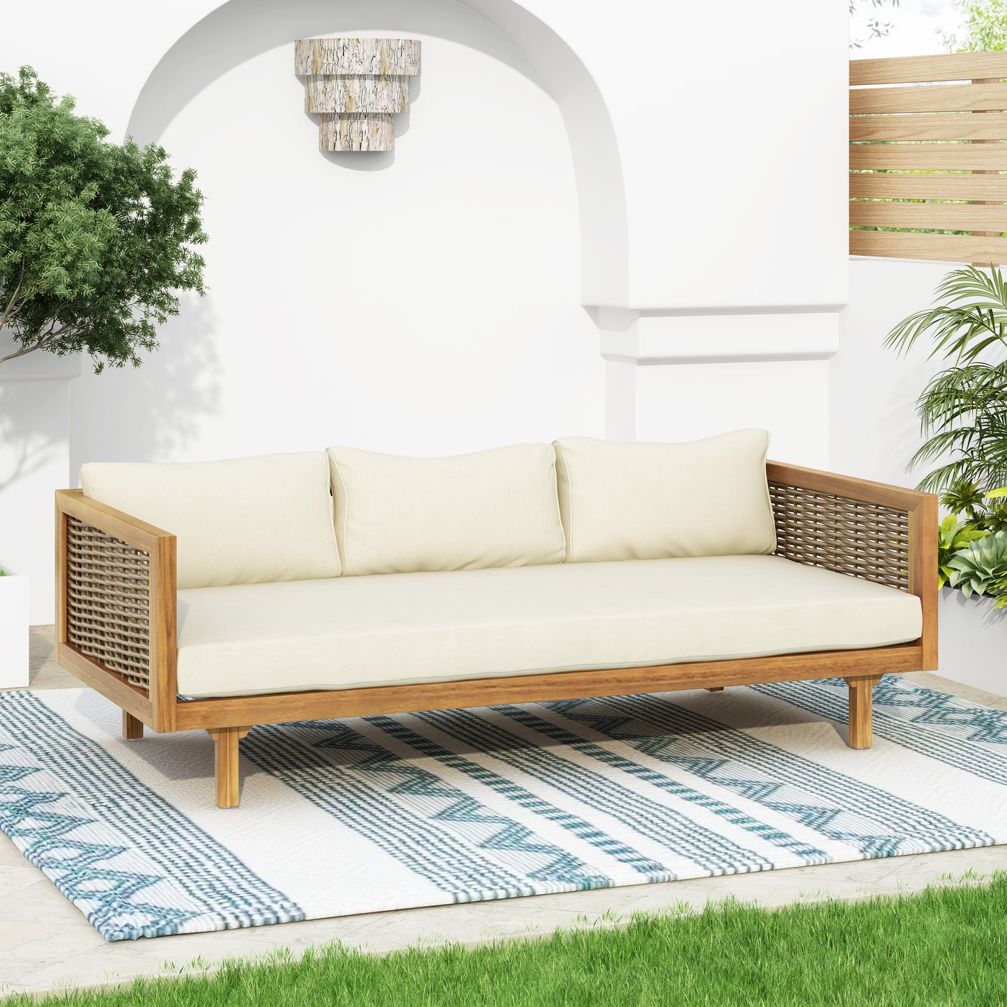 Teak frame outdoor sofa with cream cushions and woven sides perfect for patio use