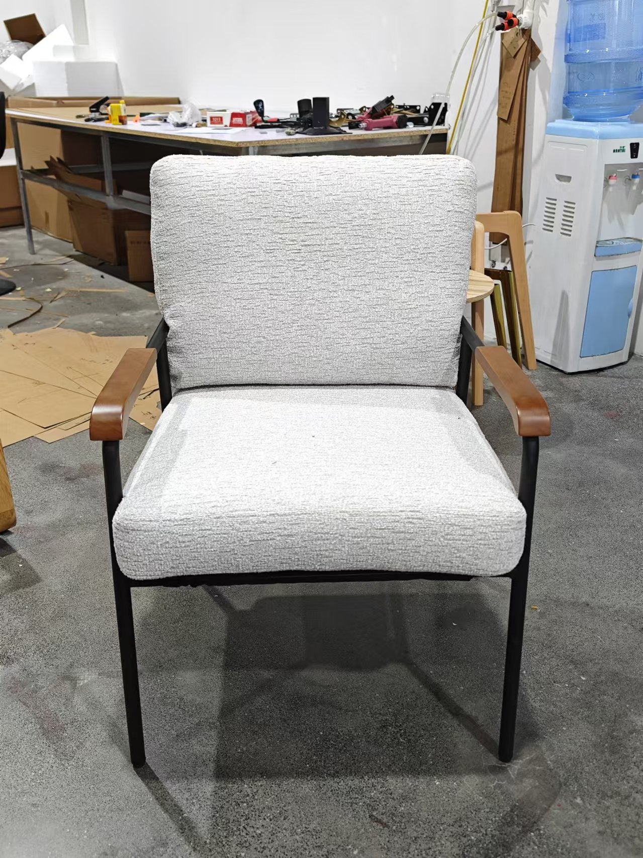 Textured light grey armchair with wooden arms and black metal frame
