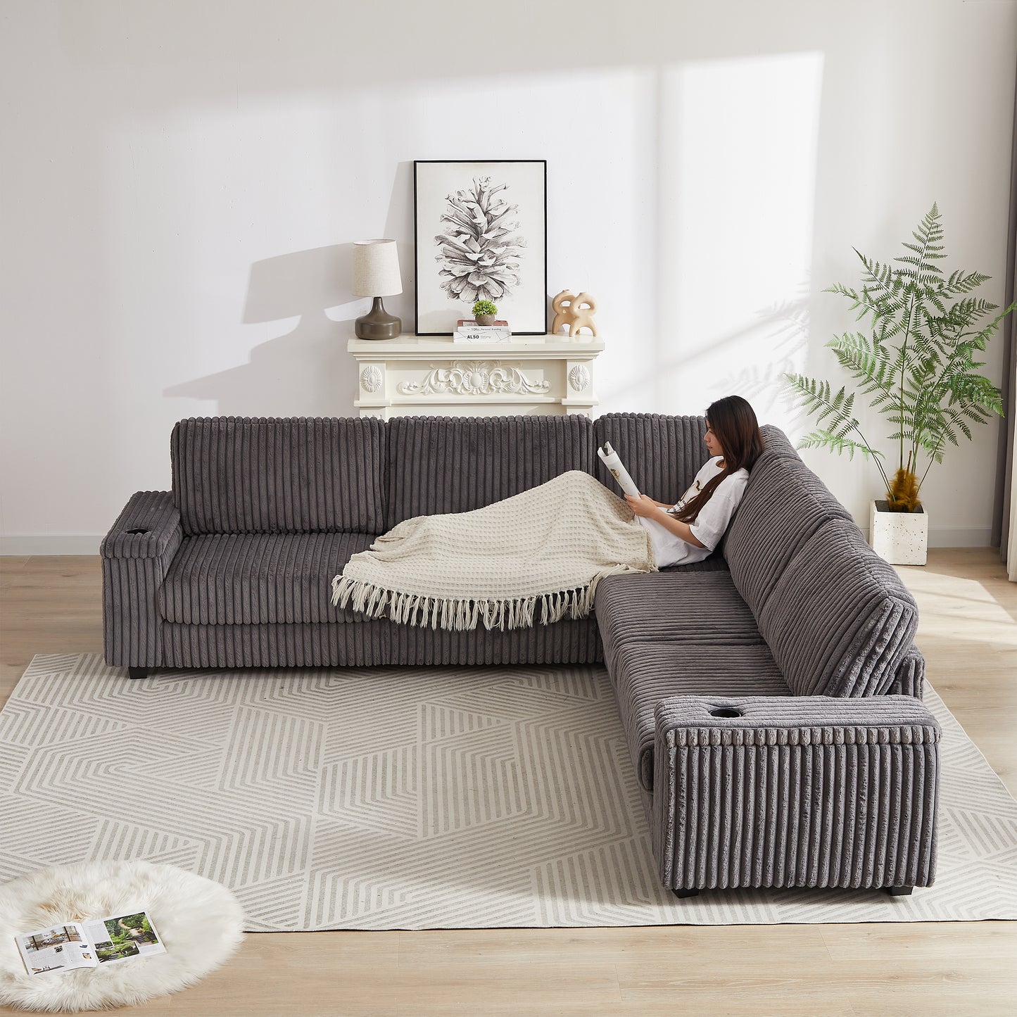 Plush grey corduroy sectional sofa with builtin cup holders and plush throw blanket
