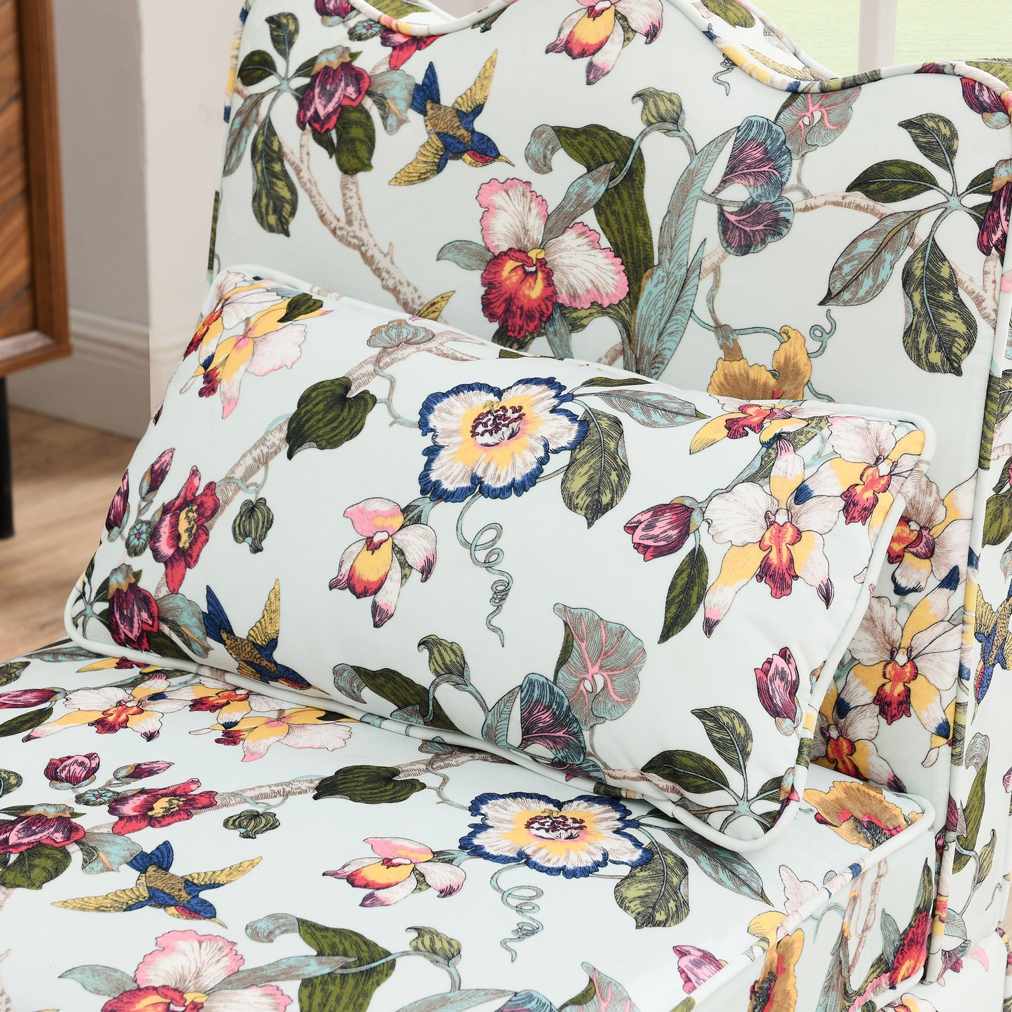 Powder blue armchair with a vibrant floral and bird print fabric
