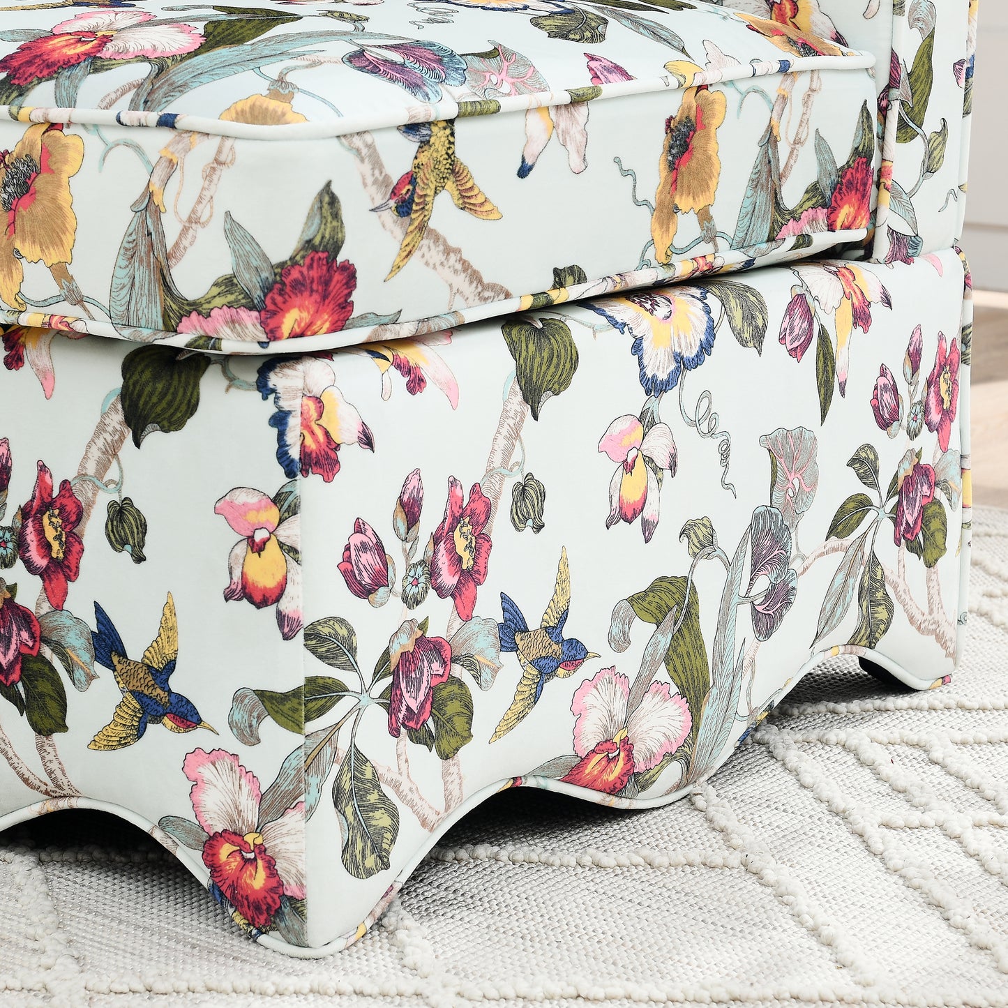 Light blue armchair with a vibrant floral and bird print upholstery