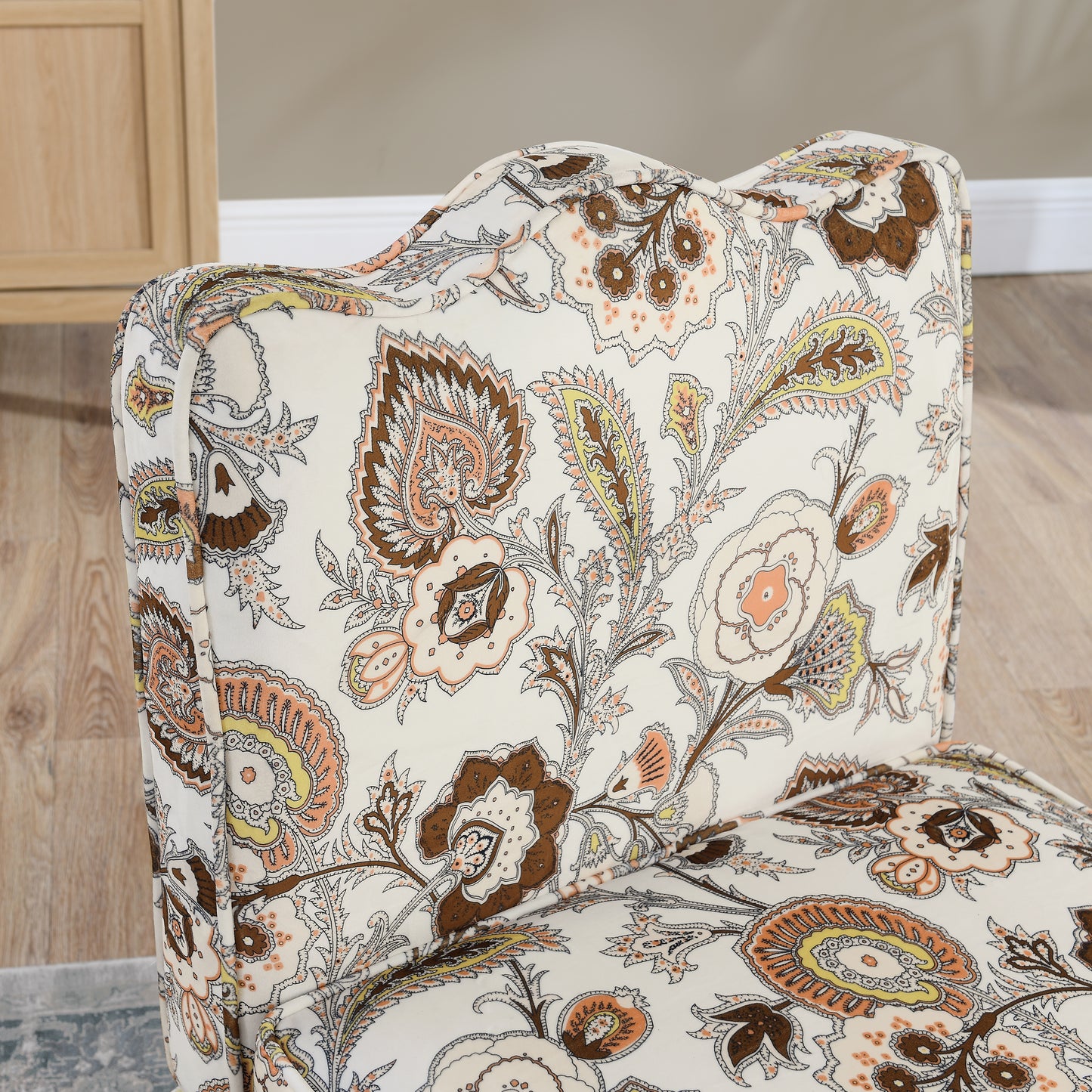 Cream accent chair with a bold paisley print in brown peach and yellow