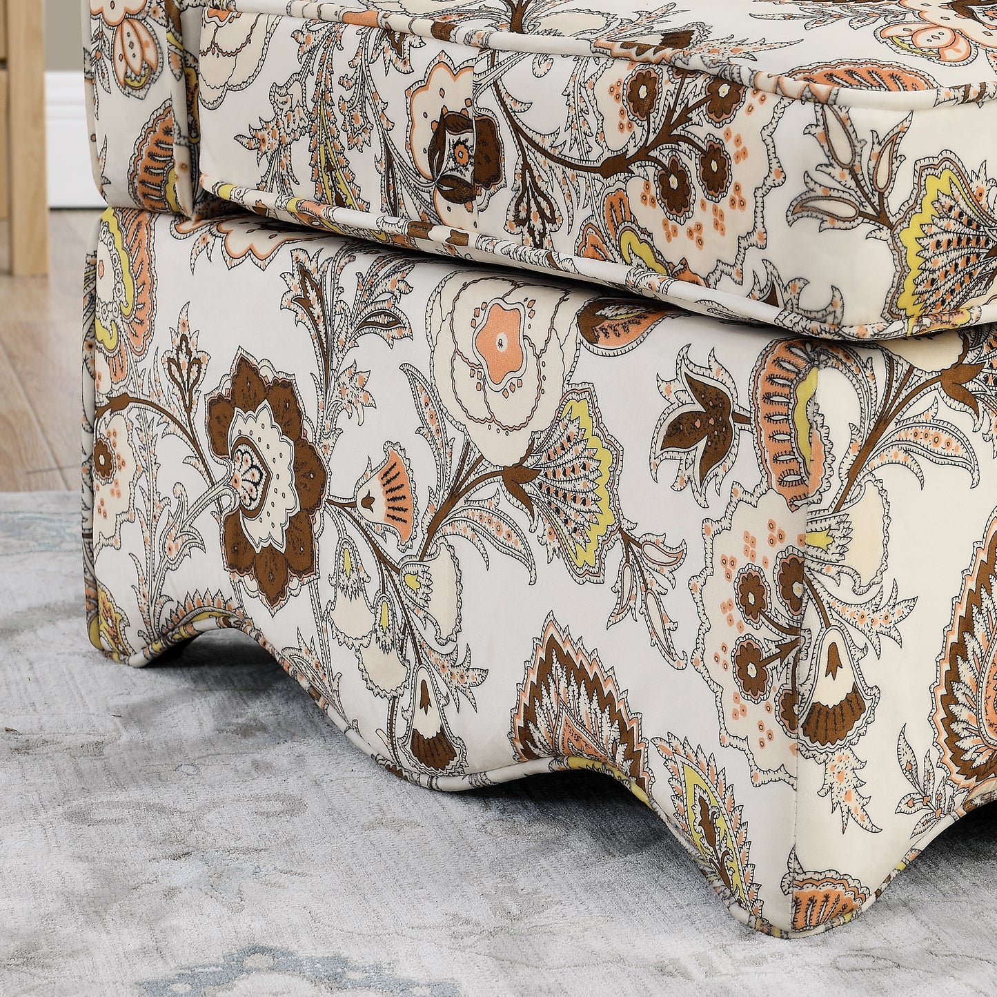 Cream upholstered armchair with ornate brown peach and yellow paisley floral pattern