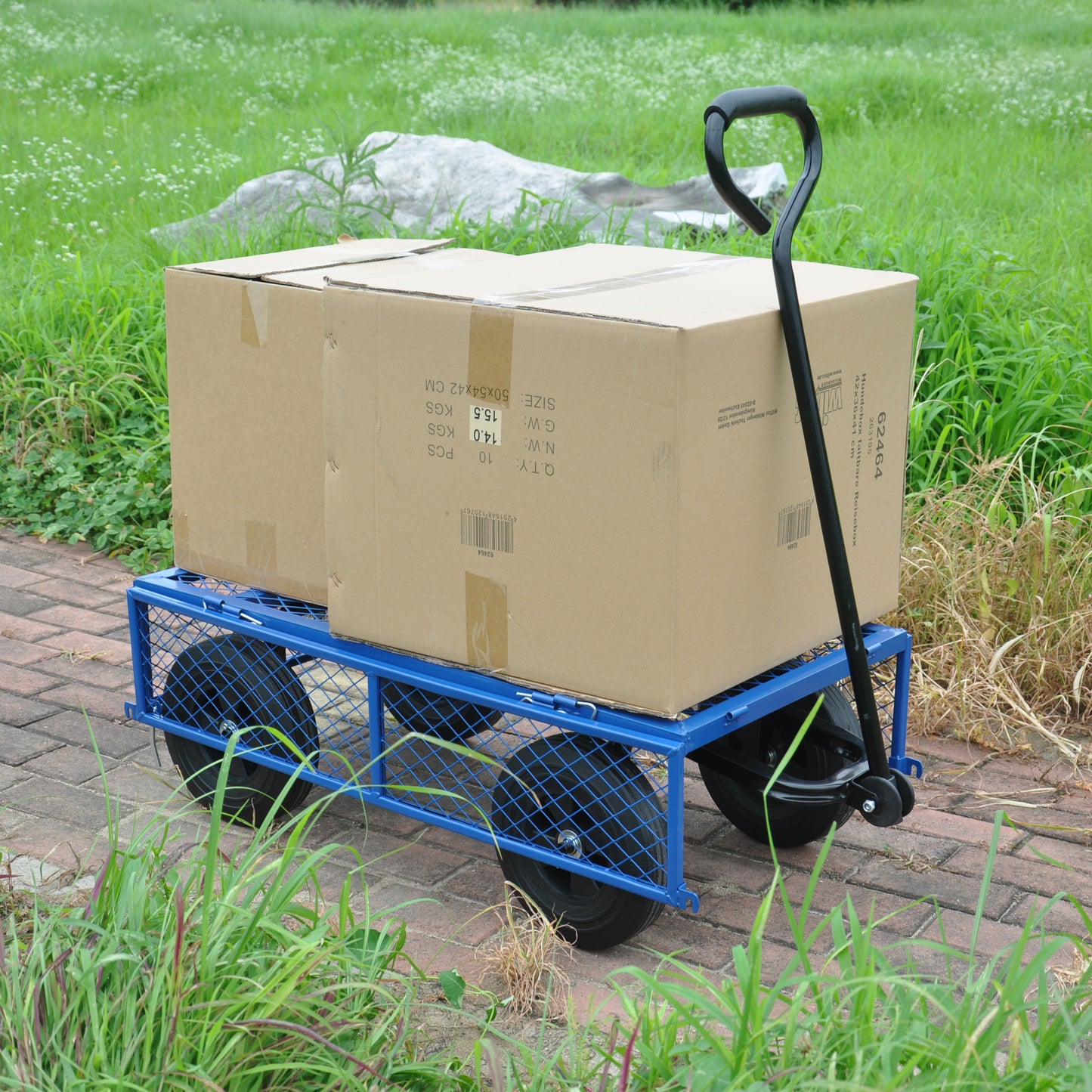 Blue garden wagon with mesh sides carrying two large cardboard boxes outdoors on a brick path