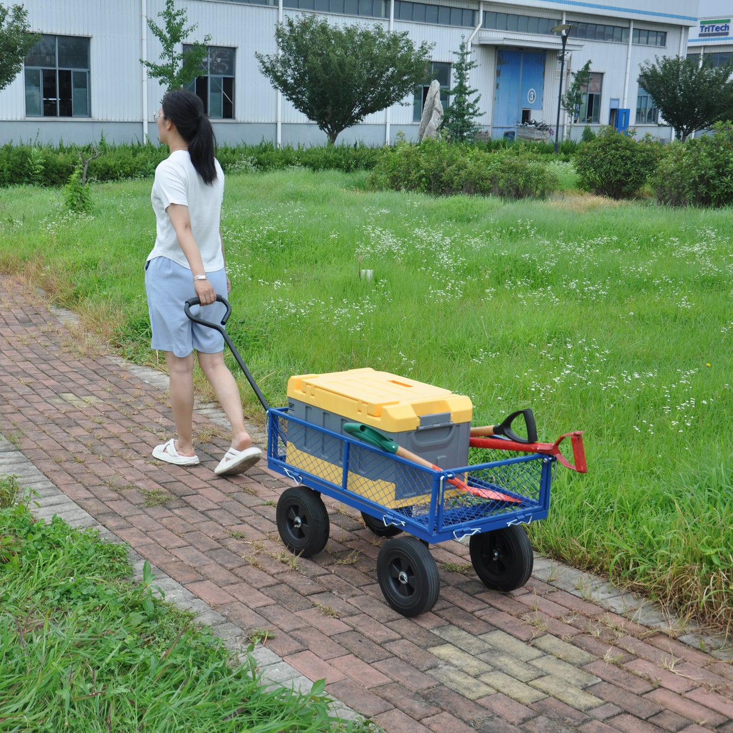 Blue steel garden wagon with yellow storage bin and tools ready for transport
