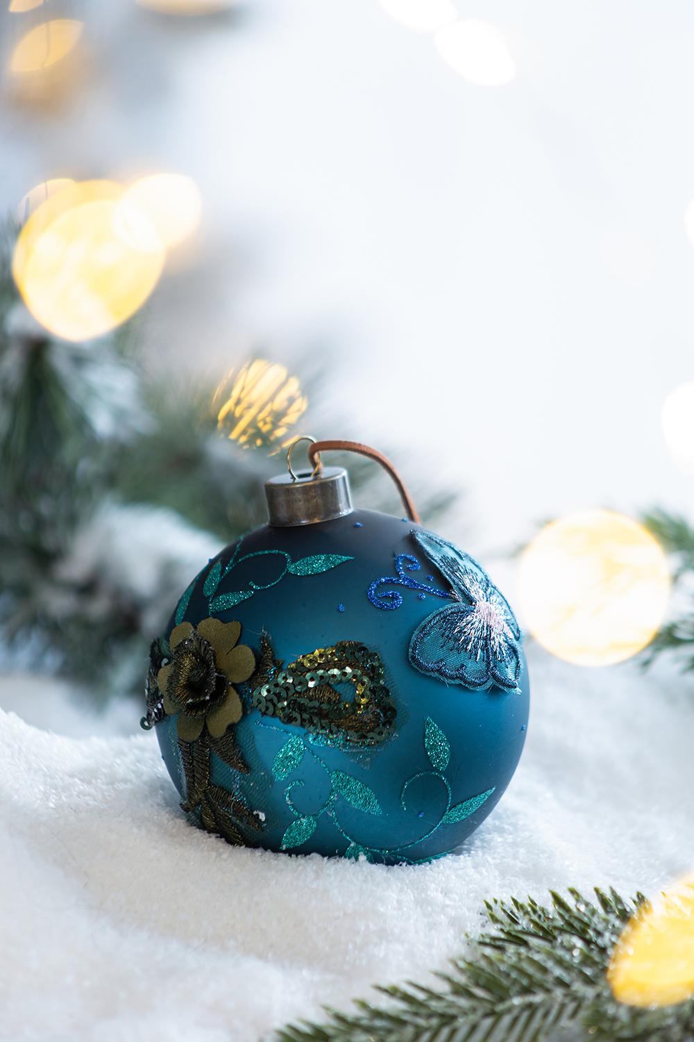 Teal glass Christmas ornament with embroidered floral and butterfly designs