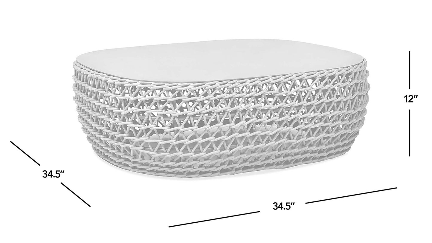 White wicker coffee table with textured weave and light grey cushion