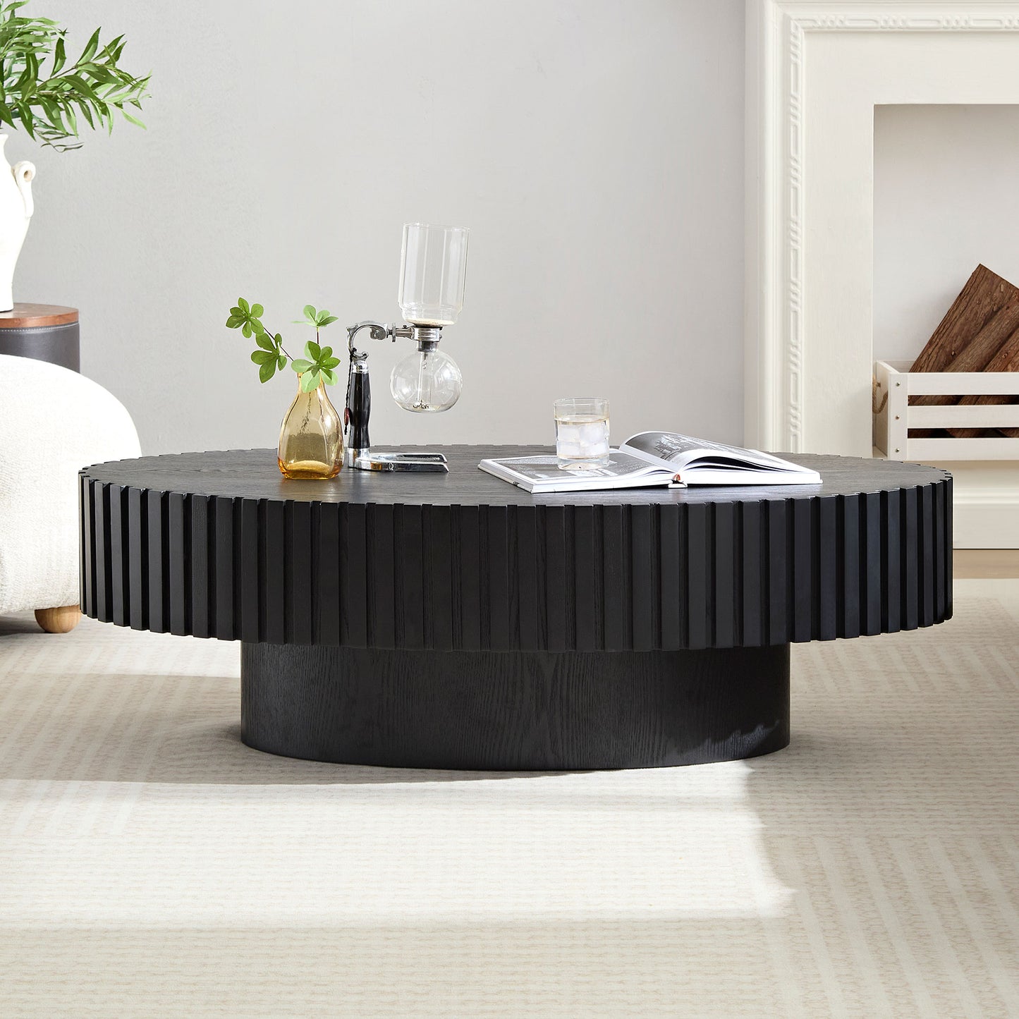 Fluted black wood coffee table with a modern pedestal base in a living room setting