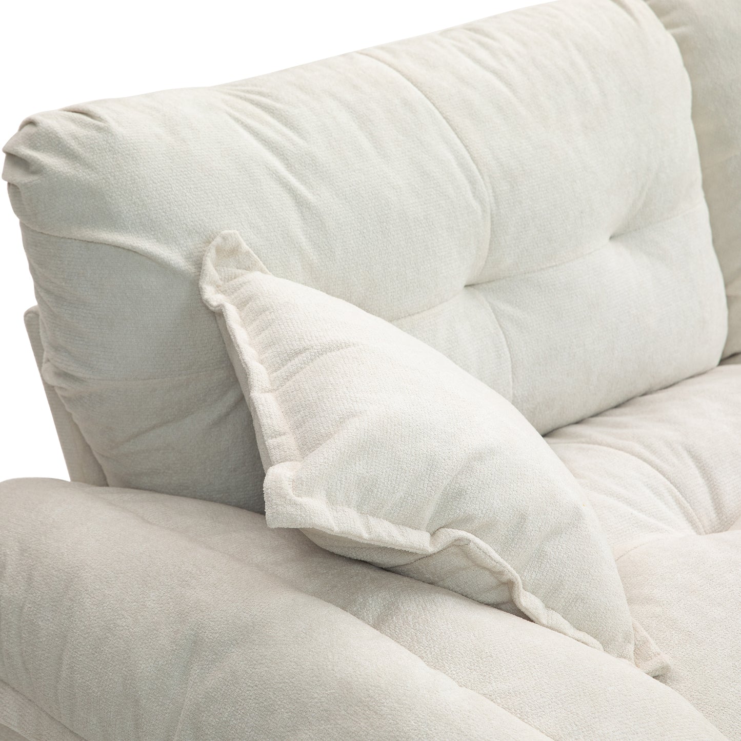 Plush cream sofa with tufted back cushions and a loose throw pillow for comfort