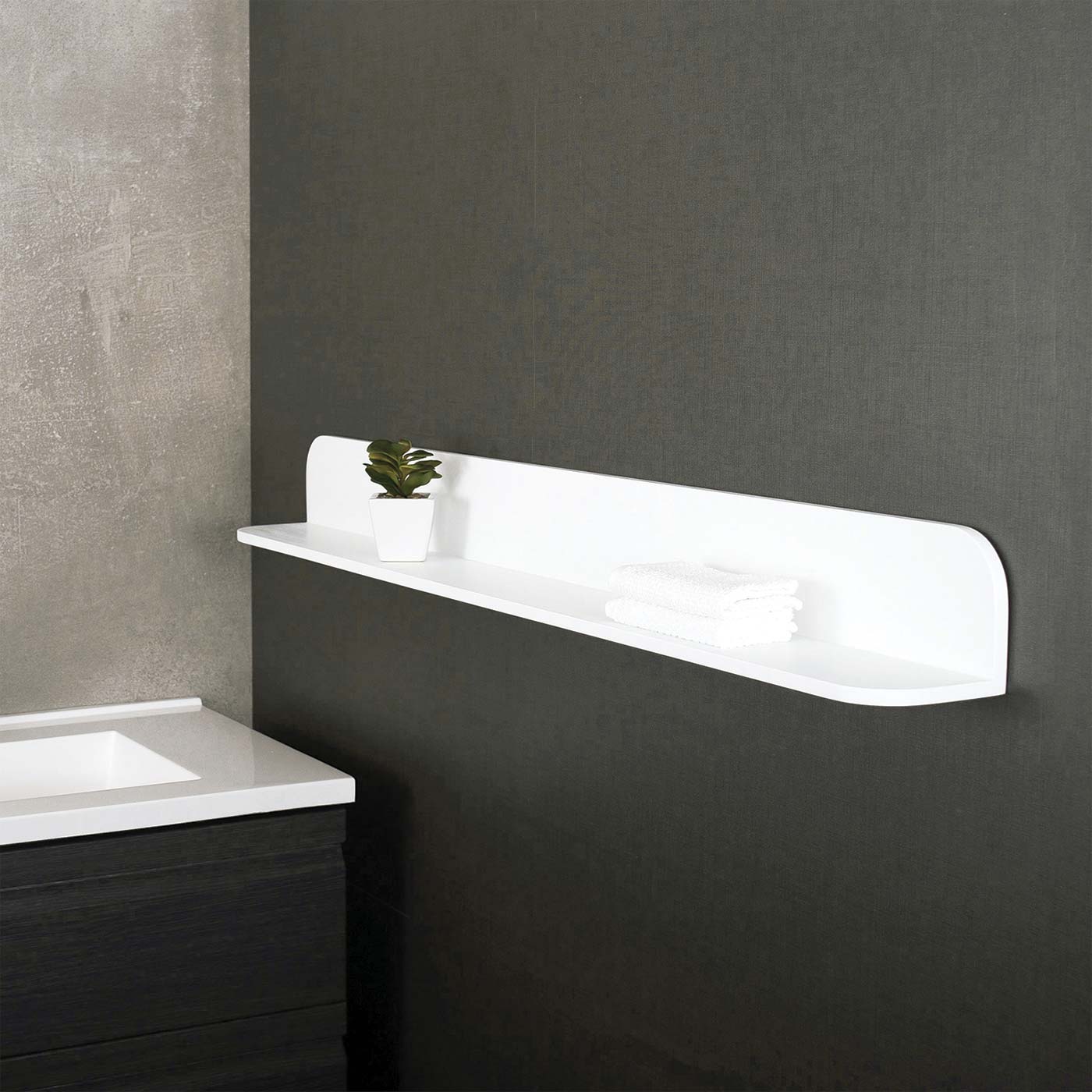 Modern white bathroom shelf with rounded edges holding a small plant
