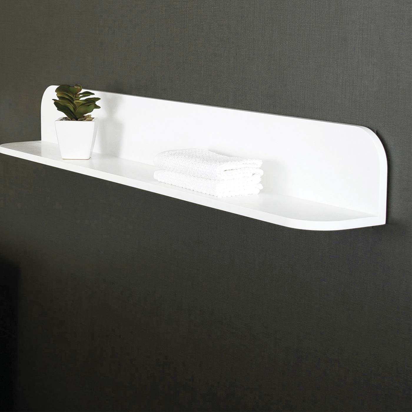 Modern white wall shelf with rounded edges holding a small potted plant and folded towels