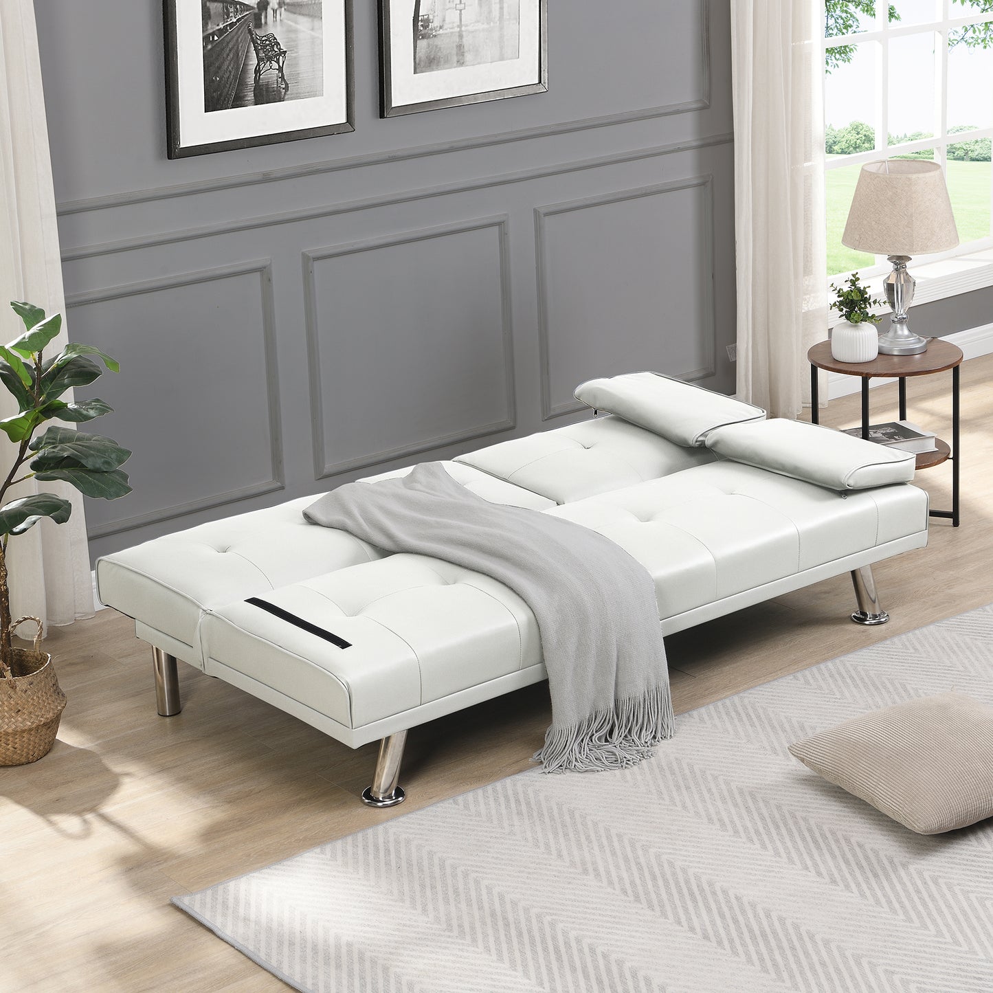 White faux leather futon sofa bed with tufted stitching and chrome legs