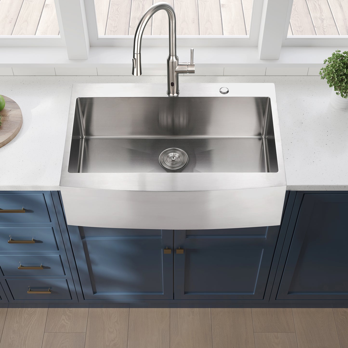Stainless steel farmhouse sink with a brushed finish and curved apron front