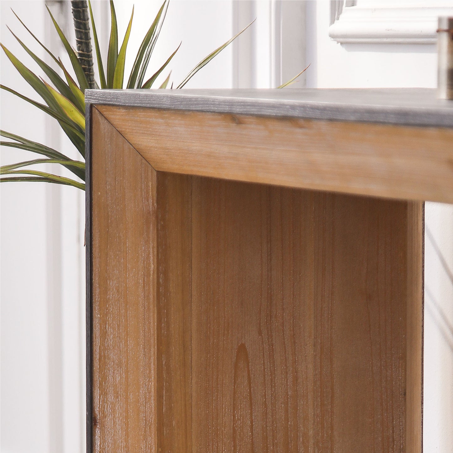 Closeup of natural wood console table with dark metal trim showcasing wood grain texture
