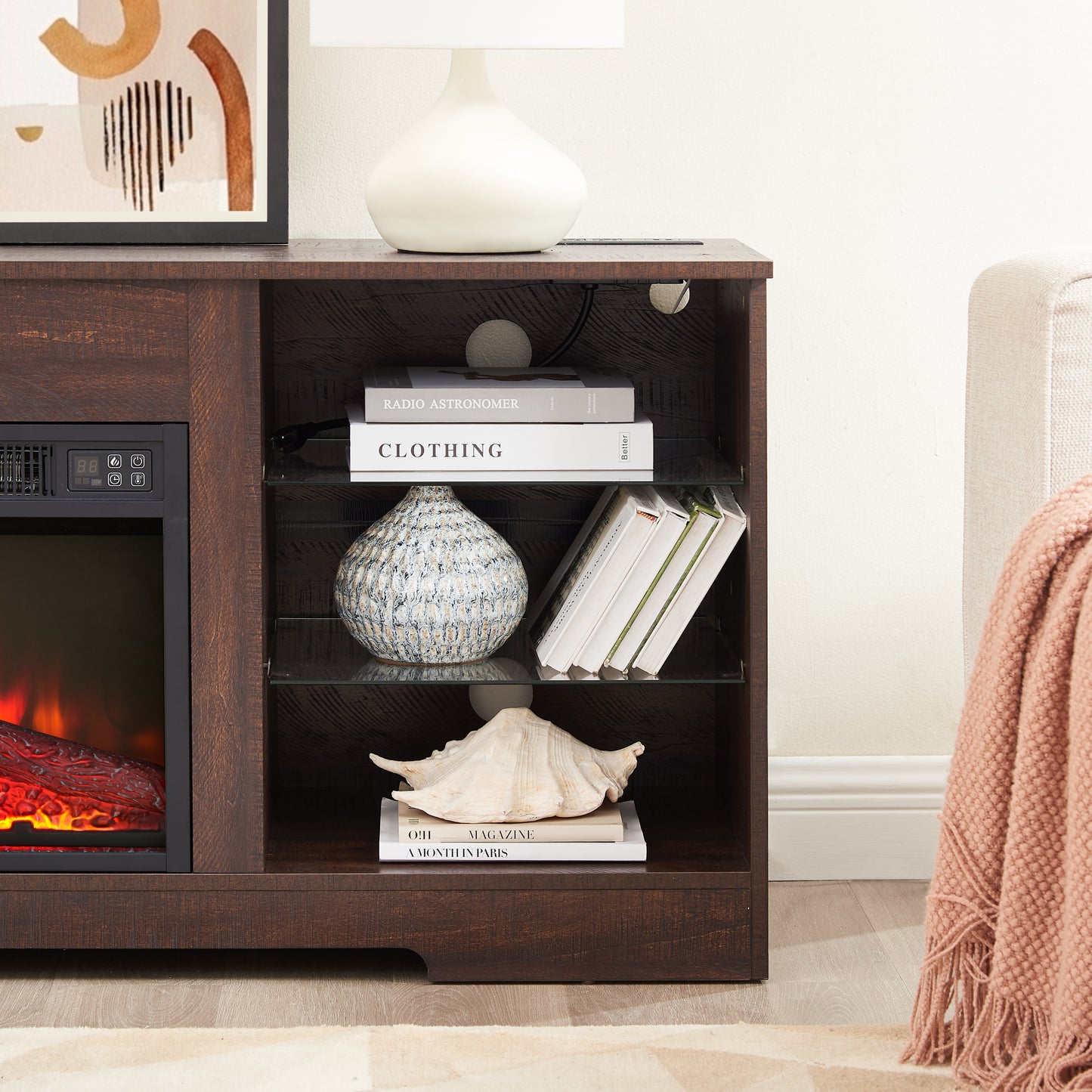 Dark wood TV stand with faux fireplace electric heater controls and open shelving with decorative items