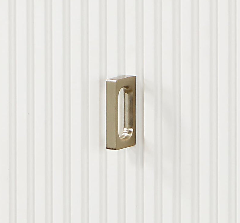 Brushed nickel recessed cabinet pull with rectangular opening on fluted white door
