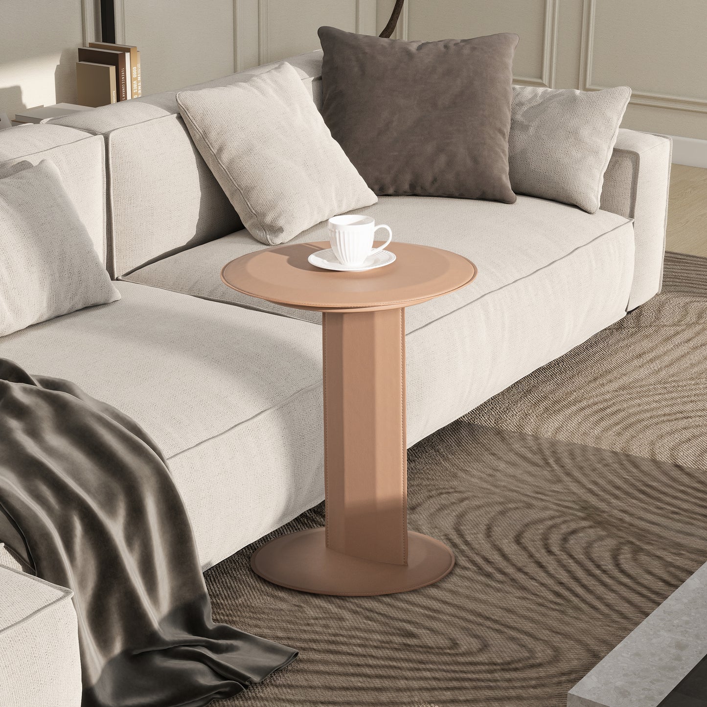 Tan leather accent table with round top beside plush sofa