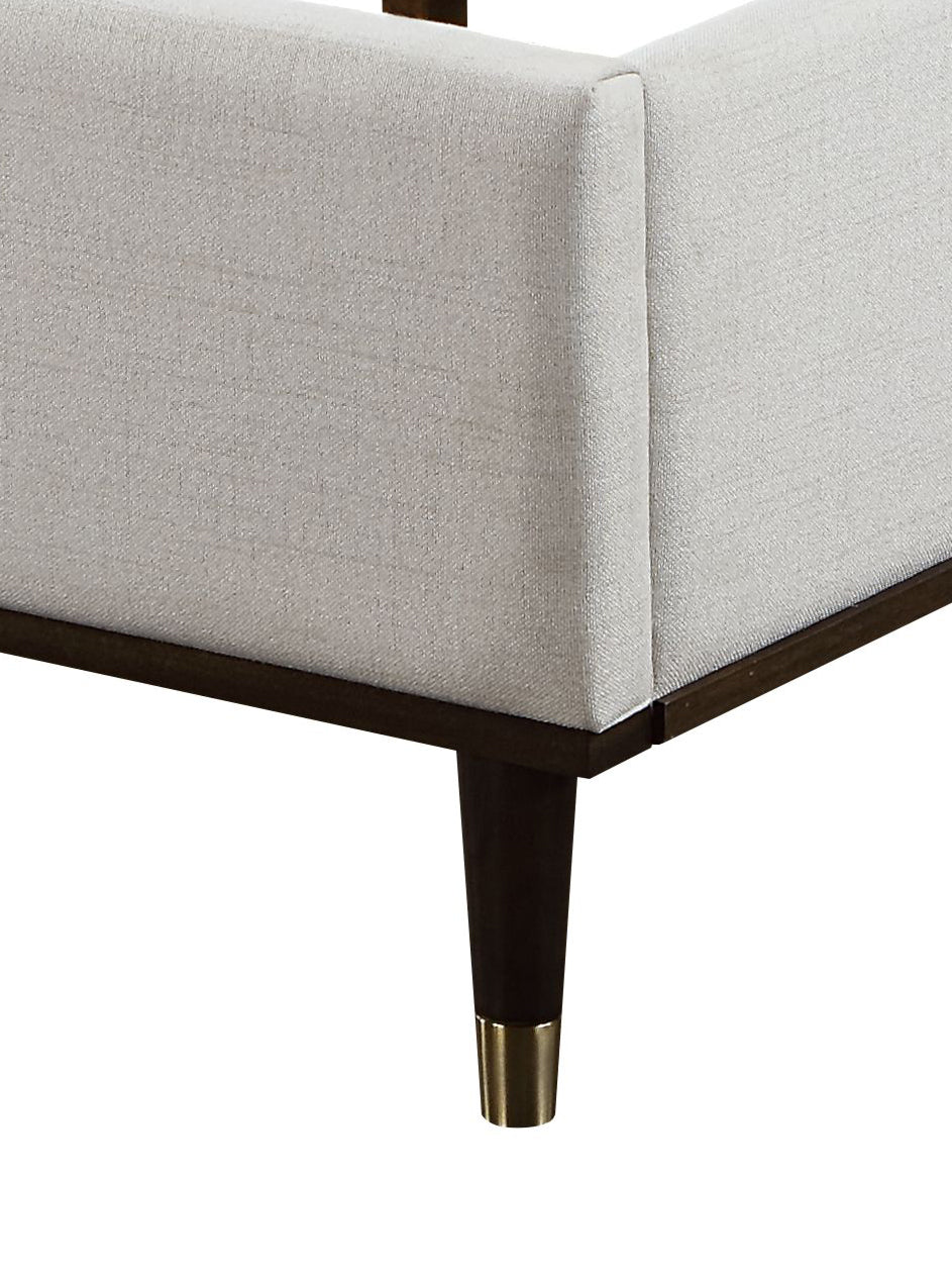 Upholstered light gray fabric bed frame with dark wood legs and gold accents