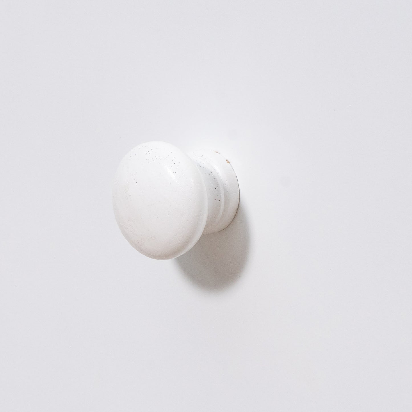 White ceramic cabinet knob with distressed finish and round shape