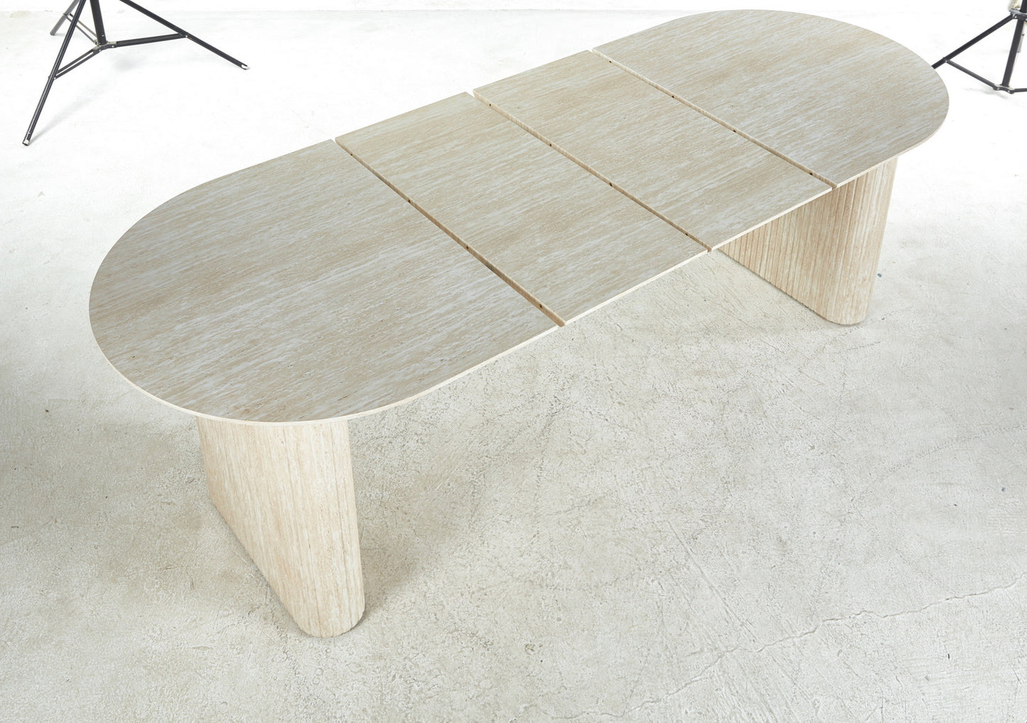 Light beige travertine dining table with oval top and fluted pedestal legs