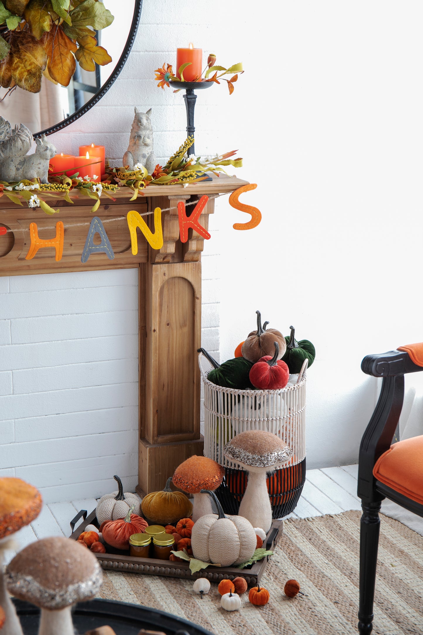 Felt THANKS banner with orange grey and yellow letters hangs on a wooden mantel