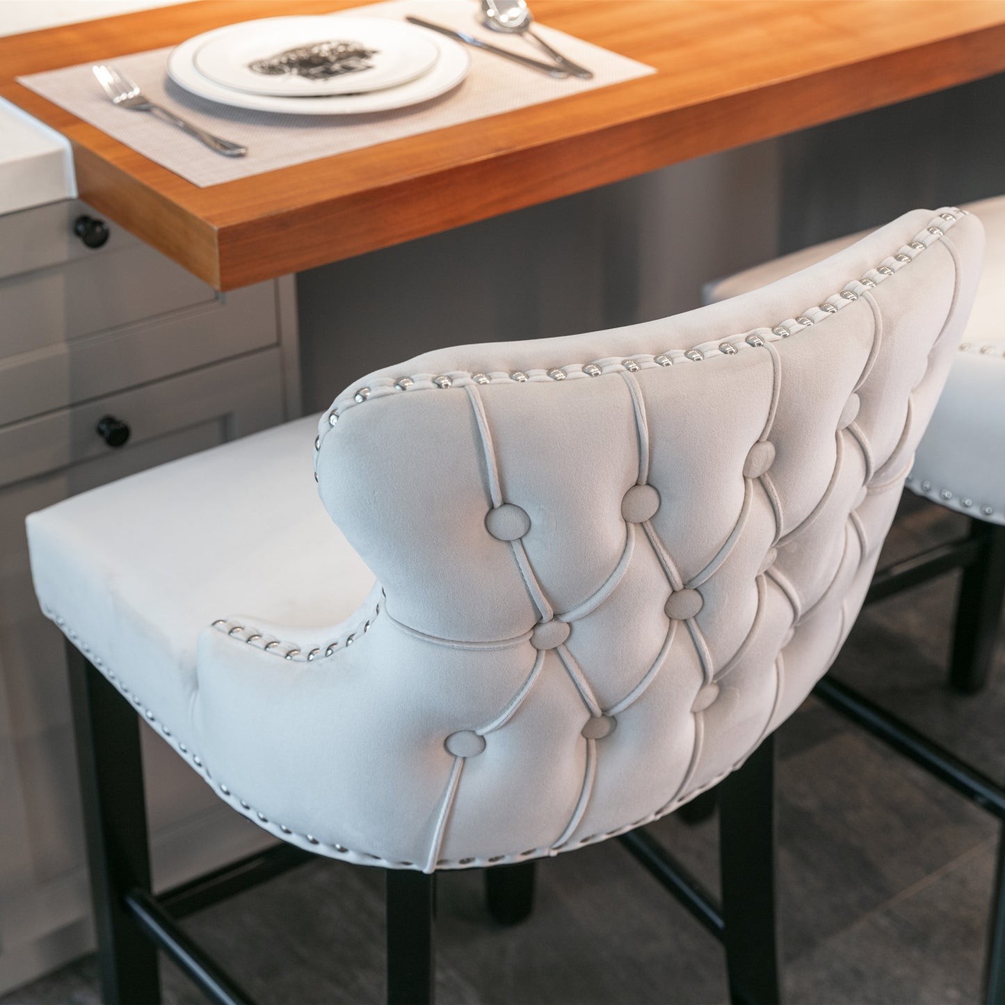 Elegant cream velvet bar stool with tufted back and silver nailhead trim