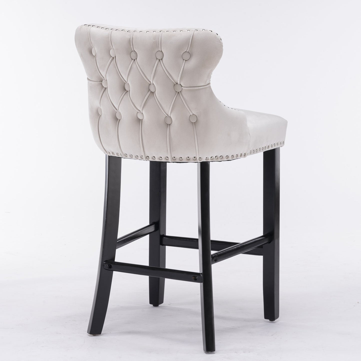 Tufted grey velvet bar stool with silver nailhead trim and dark wood legs