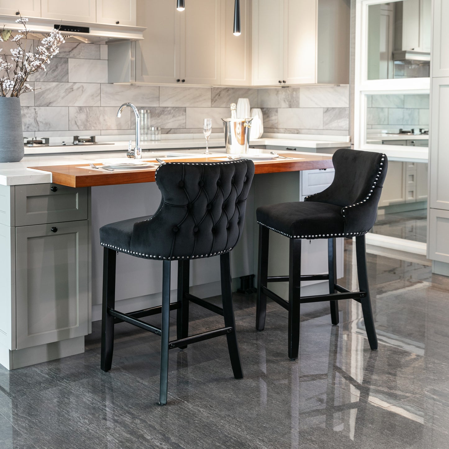 Black velvet tufted bar stool with silver nailhead trim and dark wood legs