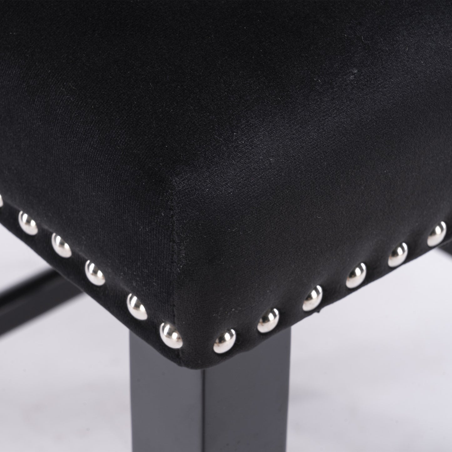Black upholstered stool seat with silver stud accents and dark metal legs