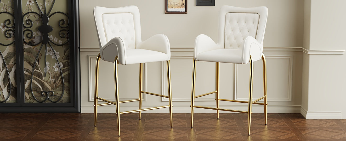 Two white velvet bar stools with diamond tufting and gold legs