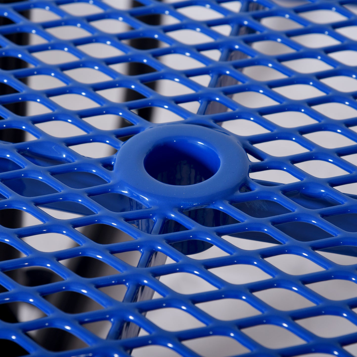 Vibrant blue expanded metal mesh table surface with integrated drink holder detail