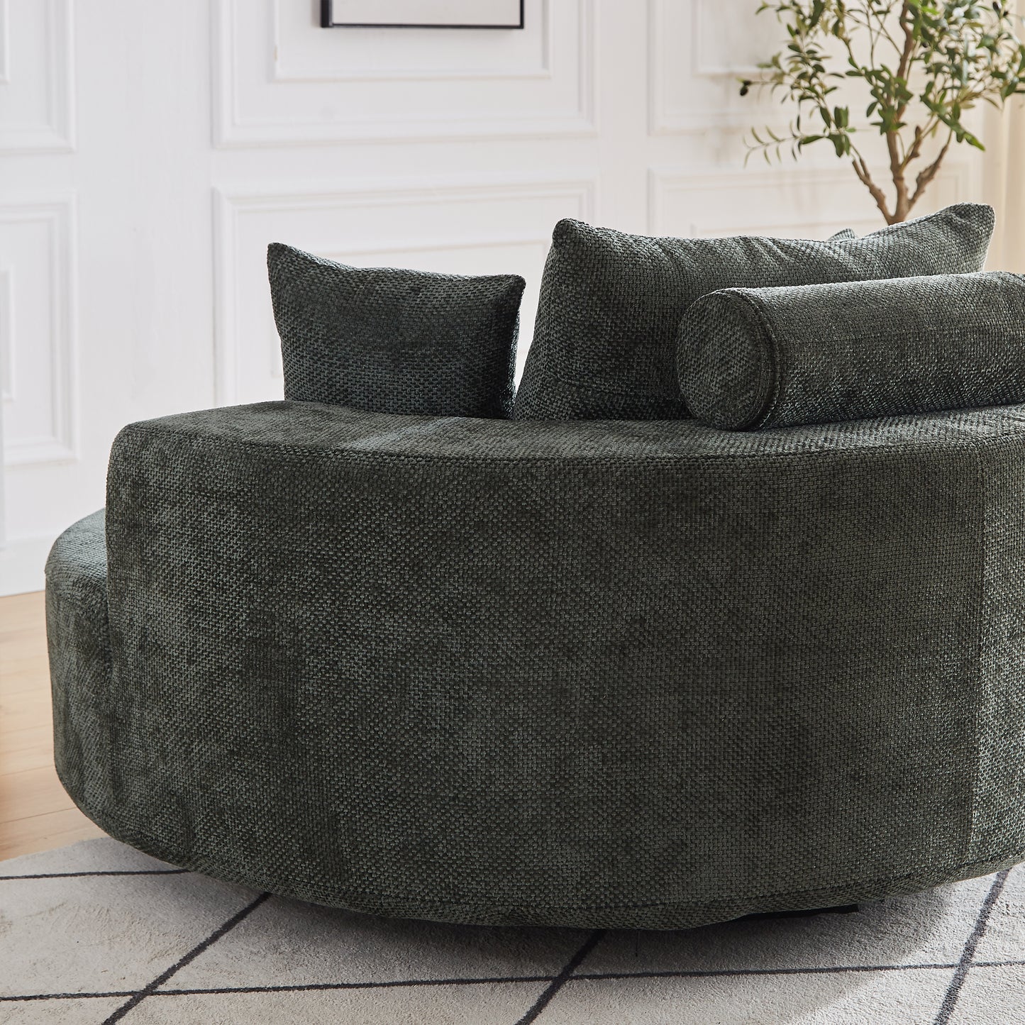 Dark green textured circular sofa with scatter cushions and bolster