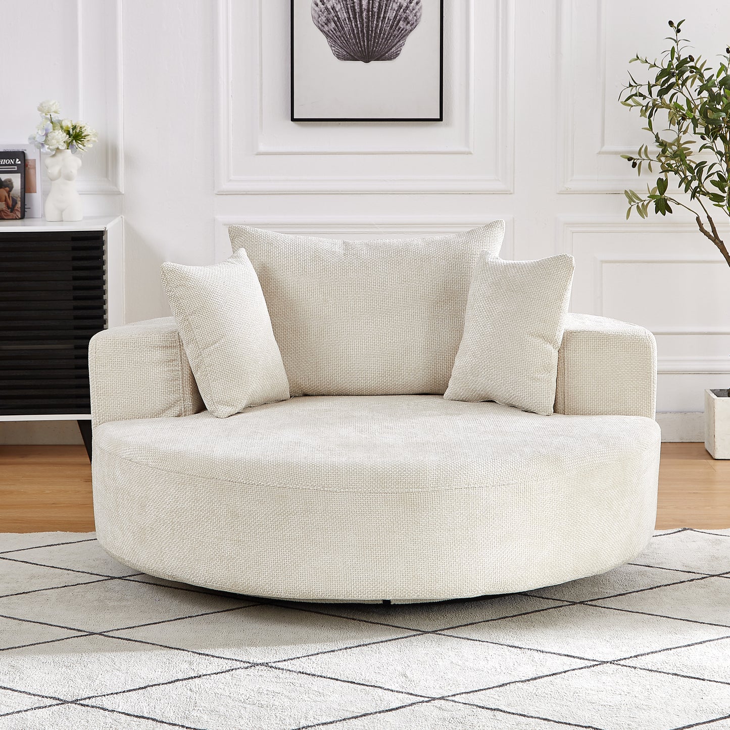 Cream boucle fabric swivel chair with rounded silhouette and two throw pillows