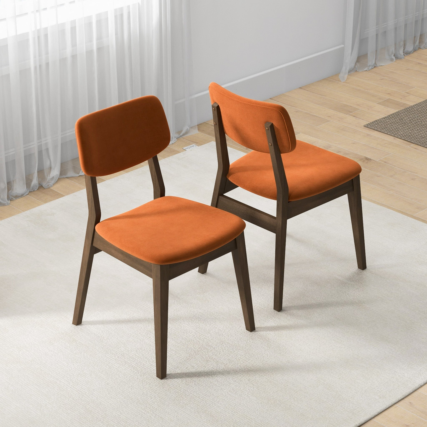 Two orange upholstered dining chairs with dark wood frames on a light rug