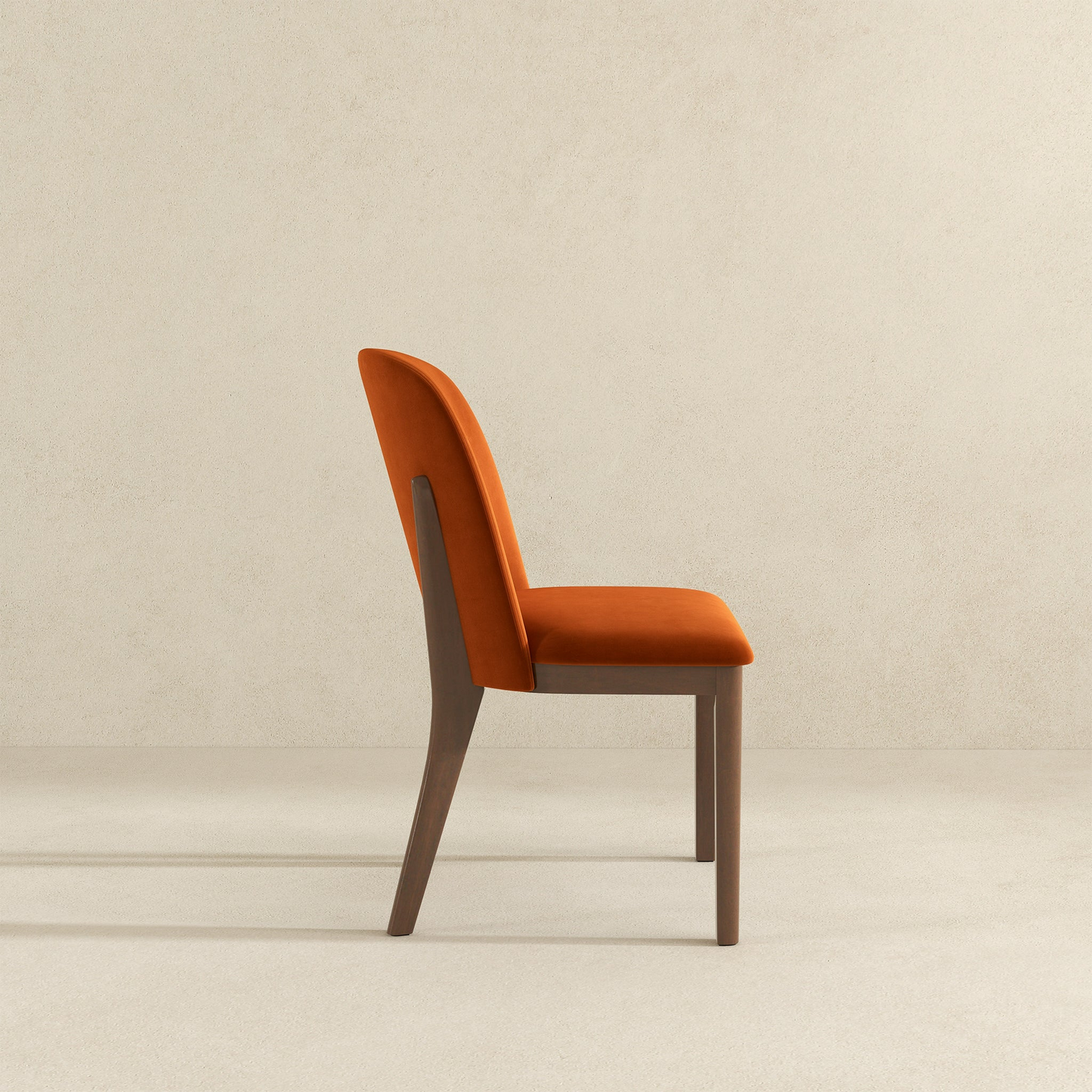 Orange velvet dining chair with wooden legs side view Perfect for modern homes