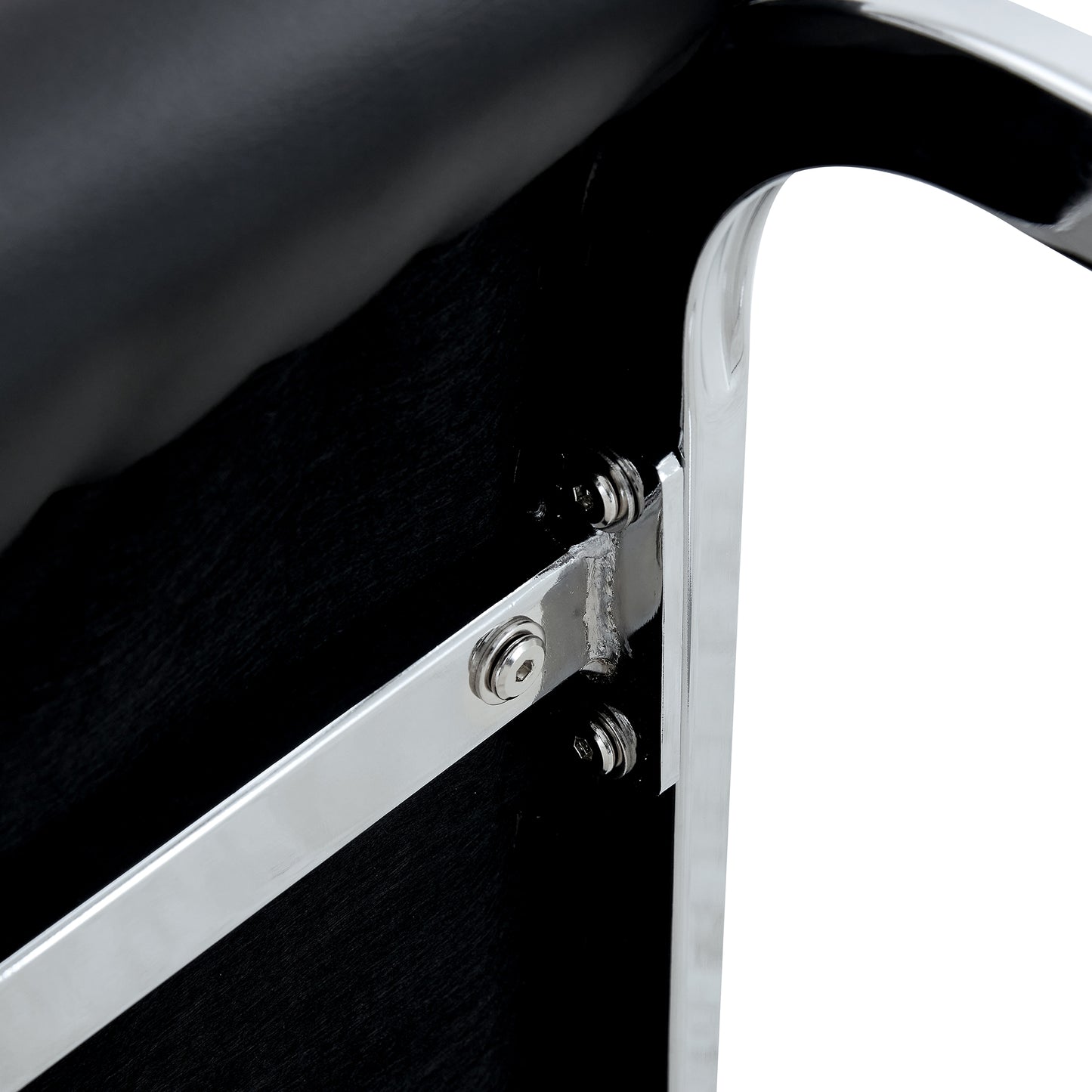 Closeup of black faux leather seat with polished chrome metal frame detail and visible screws
