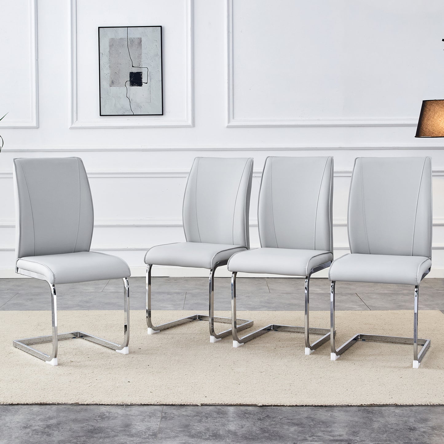 Four light grey faux leather dining chairs with chrome sled legs