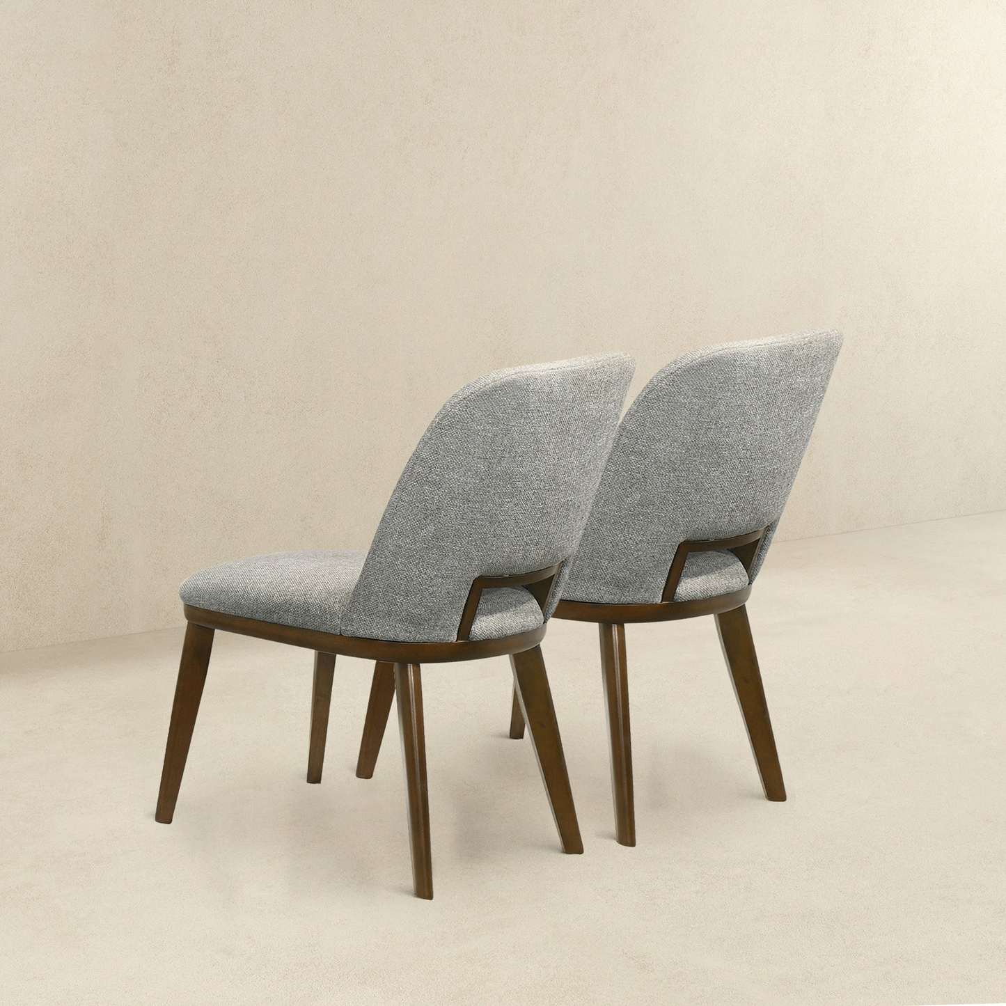 Two grey upholstered dining chairs with dark wood legs modern minimalist style