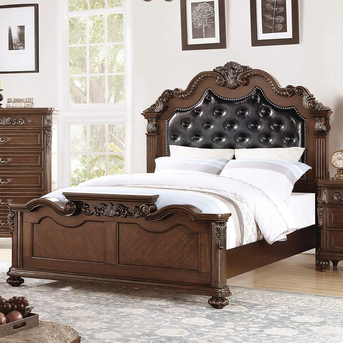Ornate brown wood bed frame with a tufted black leather headboard