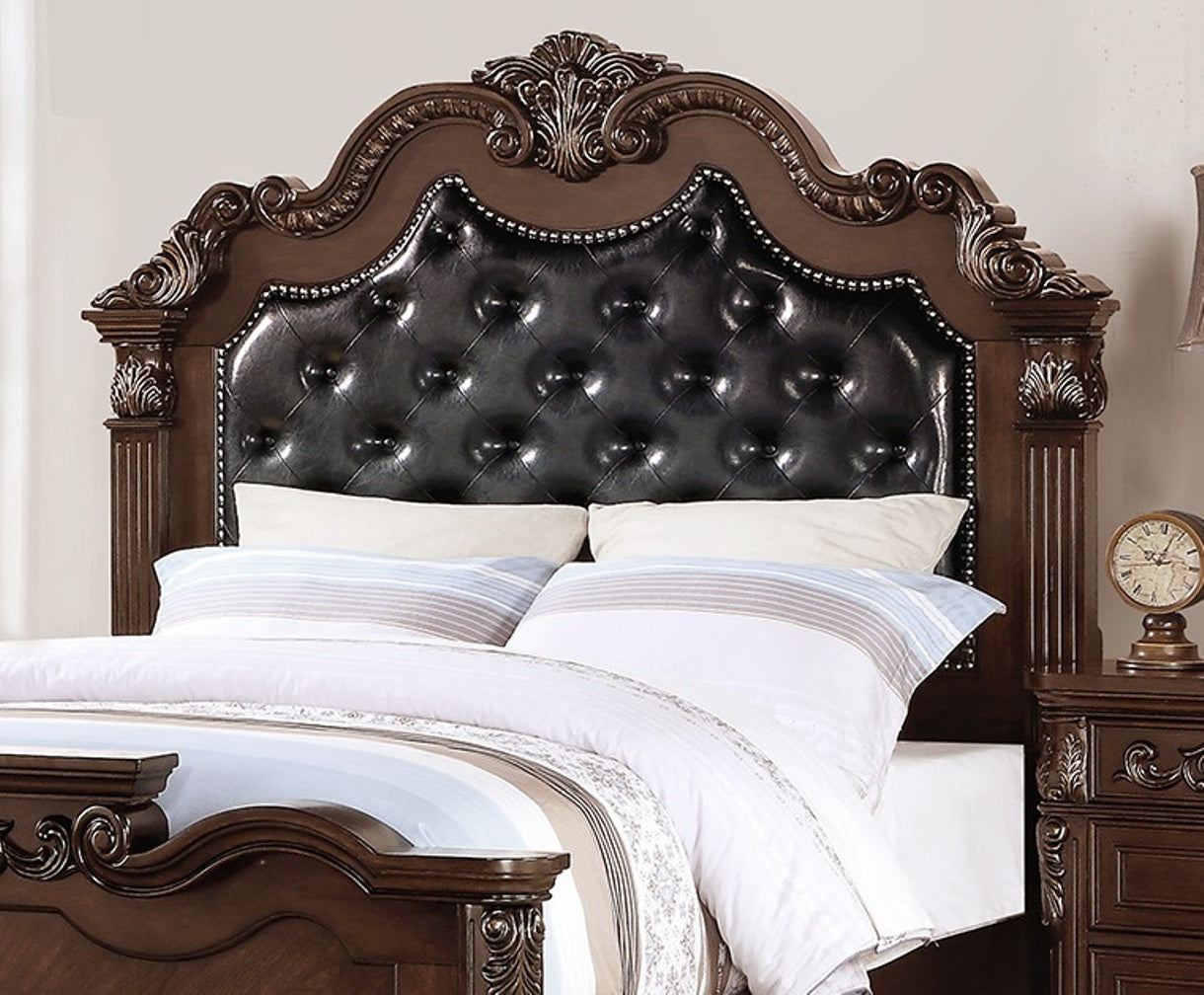 Dark wood ornate headboard with black tufted leather inlay and decorative trim