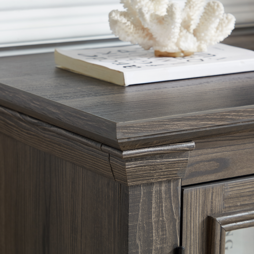 Dark brown wood cabinet corner detail with a white coral accent and book