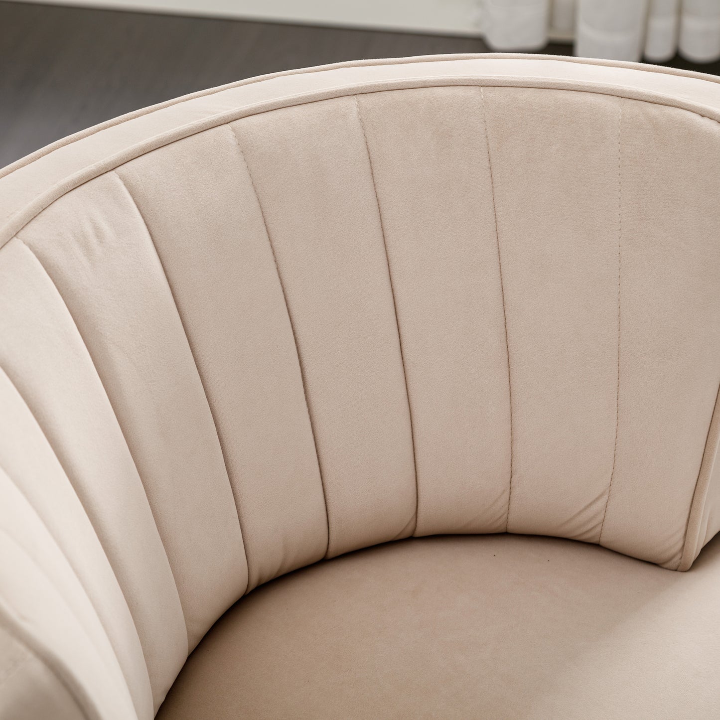 Closeup of plush beige velvet upholstery with channel tufting on a modern accent chair