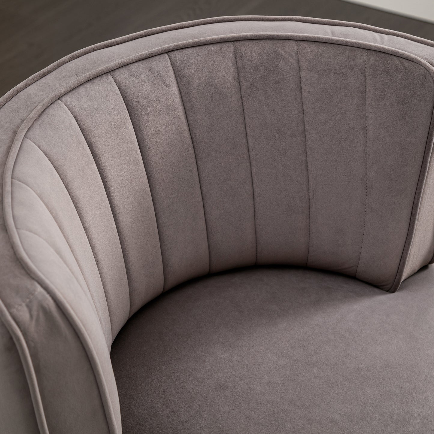Closeup of plush gray velvet accent chair with channel tufting detail