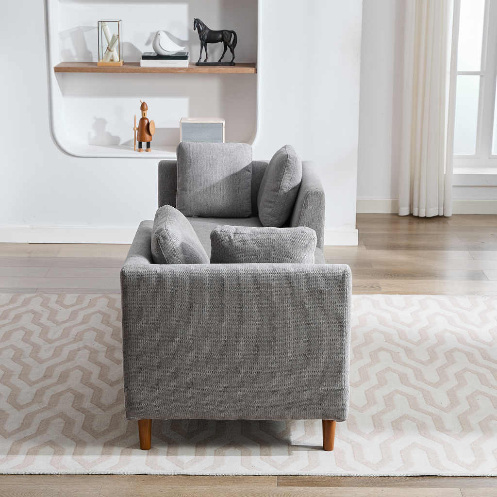 Gray fabric loveseat with plush cushions and wooden legs perfect for a living room