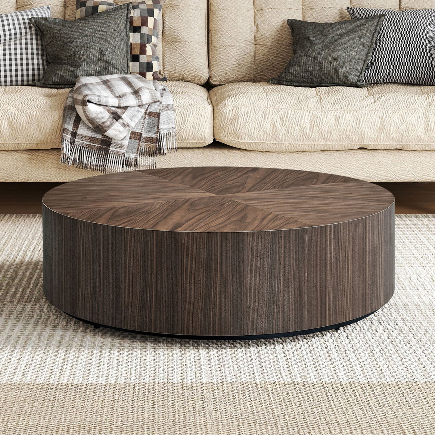 Dark wood round coffee table with a striped base on a textured rug